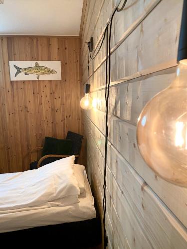 a room with a bed and a wooden wall at Lumi Guest House in Arvidsjaur