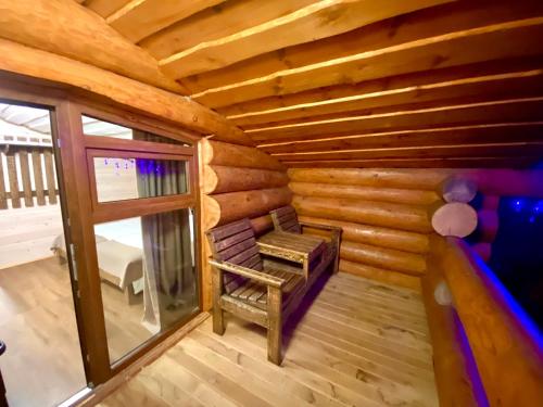an empty room with a bench in a log cabin at Complex MAYARIV in Makariv