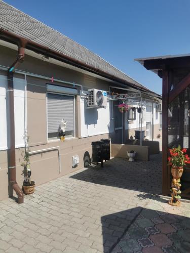 a building with a patio with a fan and a window at Edit Vendégház in Tiszaújváros
