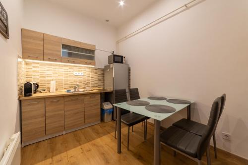 eine Küche mit einem Tisch und Stühlen sowie einem Kühlschrank in der Unterkunft Lovely 1 bedroom flat with central location in Budapest