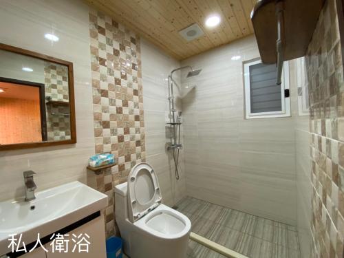 a bathroom with a toilet and a sink at Zhenan Pink Panther in Linbian