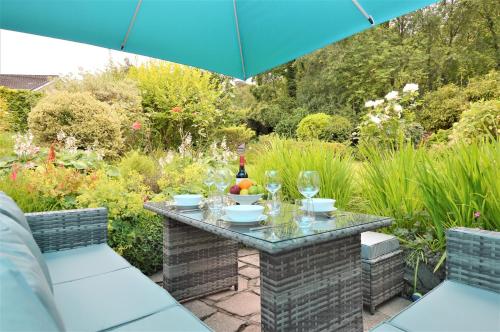 a table in a garden with a bottle of wine at Brookfield in Sandbank