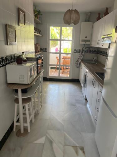 a kitchen with white cabinets and a tile floor at Pueblo Marinero in Novo Sancti Petri