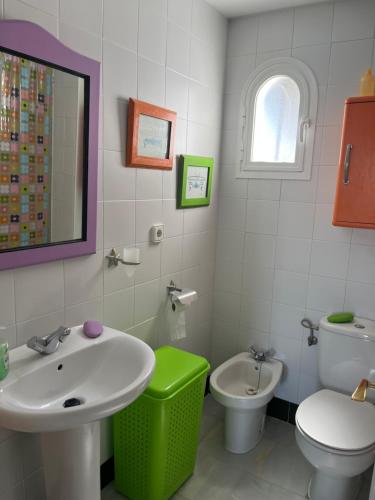 ein Badezimmer mit einem Waschbecken, einem WC und einem Spiegel in der Unterkunft Pueblo Marinero in Novo Sancti Petri