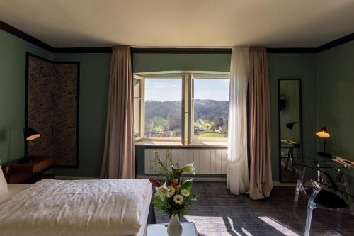 a bedroom with a bed and a large window at Historik Hotel Goldener Hirsch Rothenburg in Rothenburg ob der Tauber