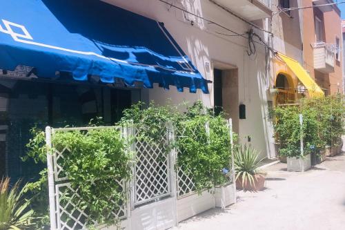 a green and white building with a blue fence at La Dimora del Viaggiatore Luxury Apartments in Mazara del Vallo