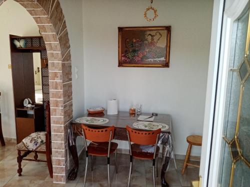 jadalnia ze stołem i krzesłami w obiekcie Villa Anna w mieście Tríkeri
