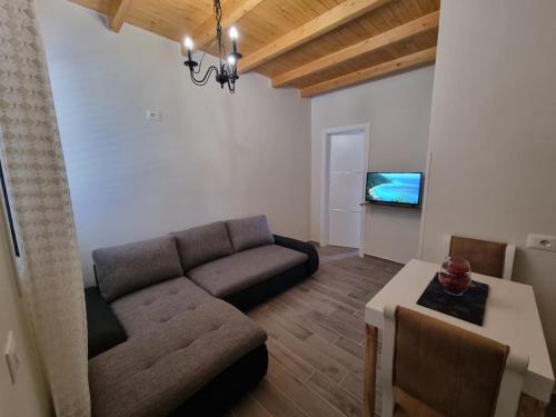a living room with a couch and a tv at Vila Soleil in Vlorë