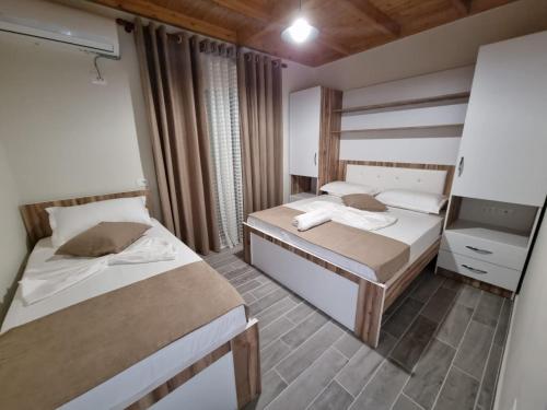 a bedroom with two beds and a mirror at Vila Soleil in Vlorë