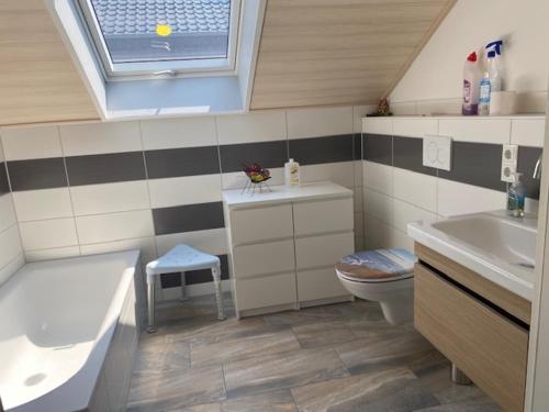 ein Bad mit einem Waschbecken, einem WC und einem Fenster in der Unterkunft Ferienwohnung Sonnenschein in Neuwied