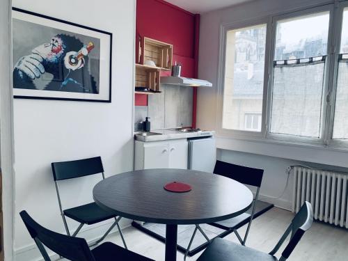 a kitchen with a table and chairs in a room at Hotel centre Rouen in Rouen