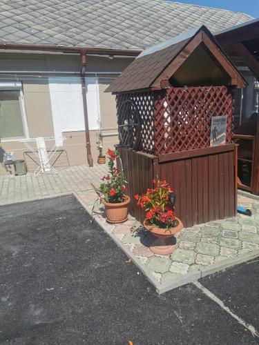 a small house with two potted plants and a fence at Edit Vendégház in Tiszaújváros