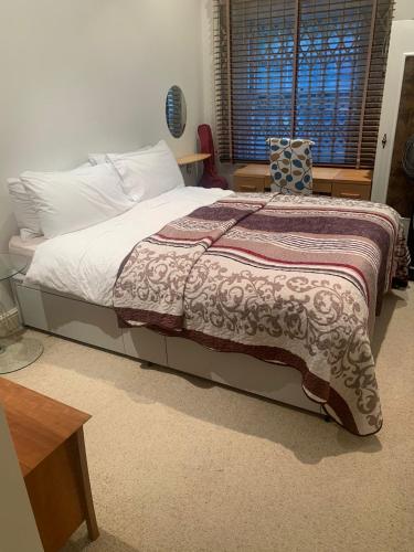 een slaapkamer met een bed met een deken erop bij spacious Knightsbridge flat in Londen