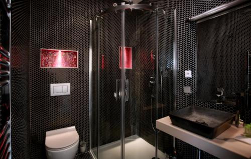 a bathroom with a shower and a toilet and a sink at Absolutum Wellness Hotel in Prague