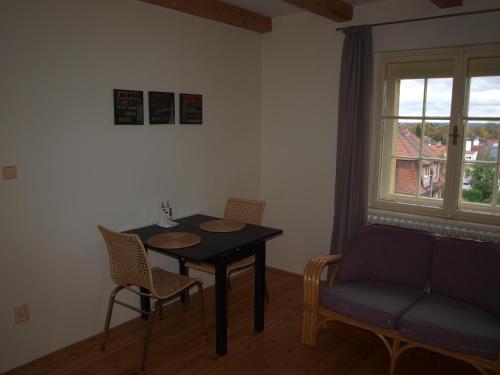 ein Esszimmer mit einem Tisch, Stühlen und einem Fenster in der Unterkunft Dalimilka in Leitmeritz