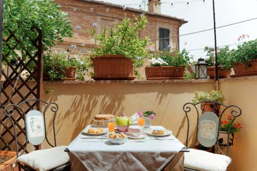 einen Tisch mit Essen auf der Terrasse in der Unterkunft B&B La Finestra Sul Campanile in Montecosaro