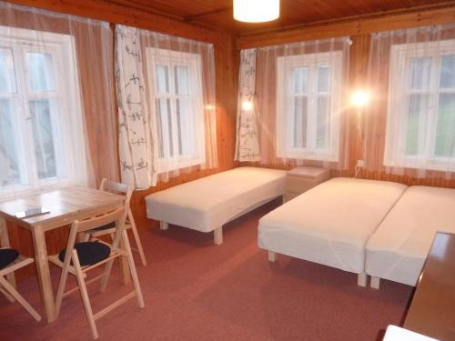 een kamer met 2 bedden, een bureau en ramen bij Chata U Vleku in Josefuv dul