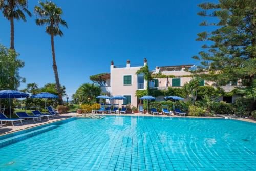 a swimming pool with chairs and umbrellas in front of a building at Hotel Villa Melodie - Adults Only in Forio d'Ischia