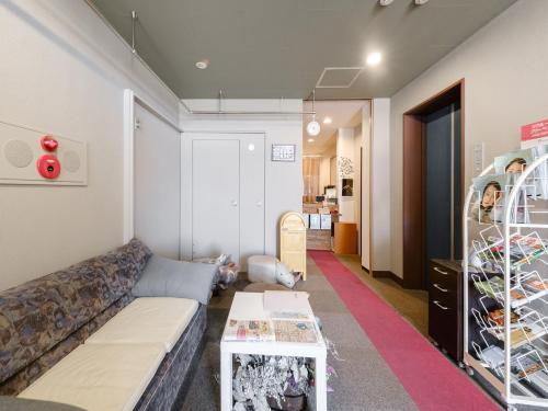 ein Wohnzimmer mit einem Sofa und einem Tisch in der Unterkunft Tabist Diversity Hotel Sin Tokiwa Asahikawa in Asahikawa