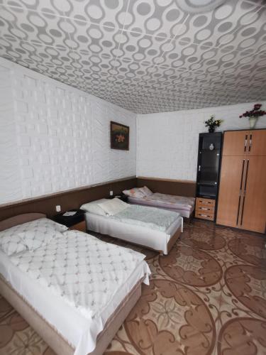 a bedroom with three beds and a coffered ceiling at Edit Vendégház in Tiszaújváros