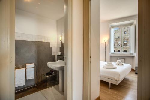 a bathroom with a bed and a sink in a room at Magia at Colosseum in Rome