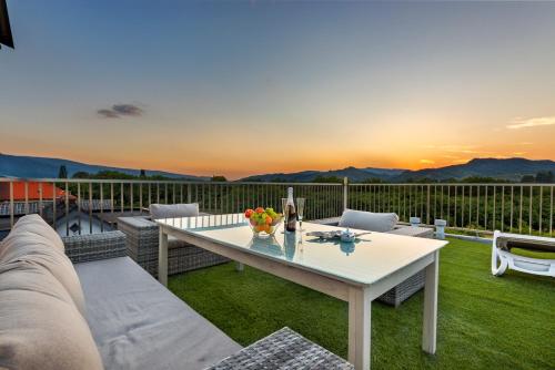 un patio con una mesa blanca y sillas en el césped en Contemporary apartment with rooftop terrace in Maribor en Maribor