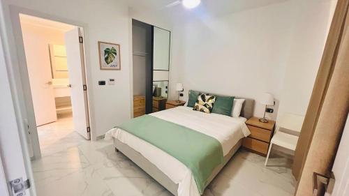 una camera con un grande letto e uno specchio di Luxury Apartment With Pool And Golf View a Punta Cana