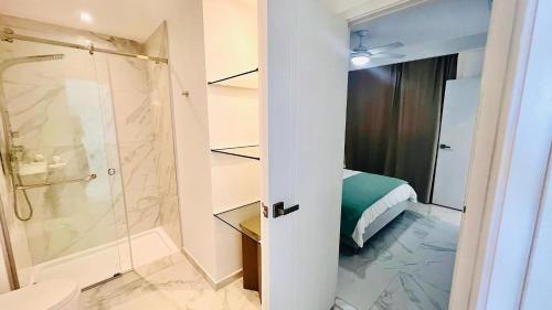 a bathroom with a shower and a toilet and a bed at Luxury Apartment With Pool And Golf View in Punta Cana