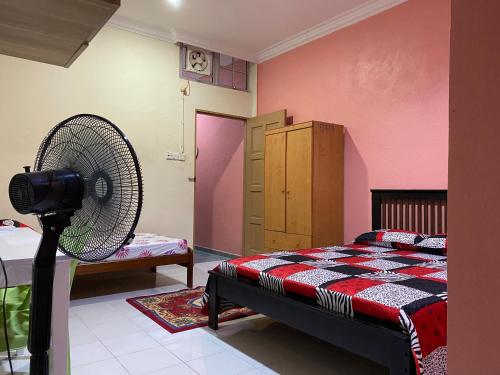 1 dormitorio con 1 cama y ventilador en Bilik Harian Pengkalan Chepa en Pengkalan Cepa