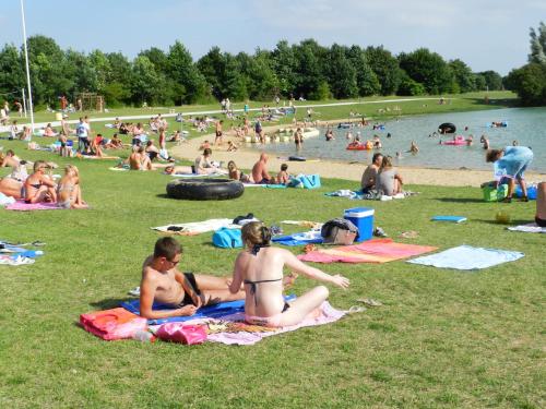 Un groupe de personnes assises sur l'herbe dans un parc dans l'établissement Détente au bord du Loir - Gîte 2, à Les Roches-lʼÉvêque