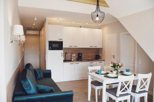 a living room and kitchen with a table and chairs at Apartamenty Wrzosowa in Dębki