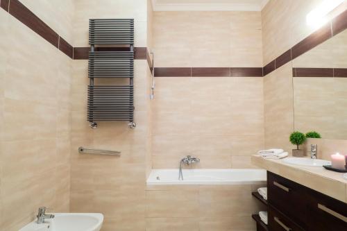 ein Badezimmer mit einer Badewanne und einem Waschbecken in der Unterkunft AS HOME Apartamenty Rynek 50 R503 in Breslau