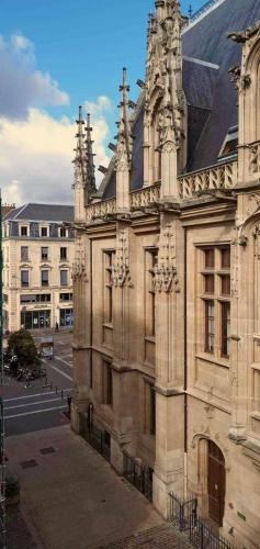 um antigo edifício de pedra numa rua da cidade em Suite Vintage Centre historique em Rouen
