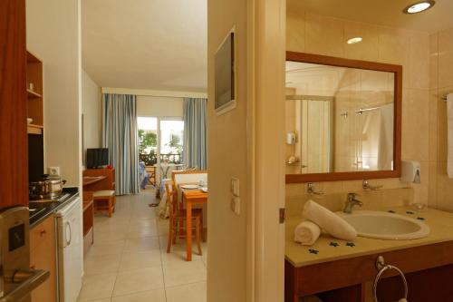 a bathroom with a sink and a living room at Indigo Mare in Plataniás