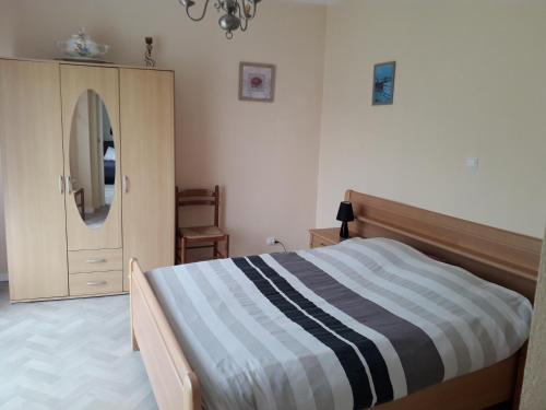 a bedroom with a bed and a dresser and a mirror at Gîte "Le Rucher" in Romanswiller