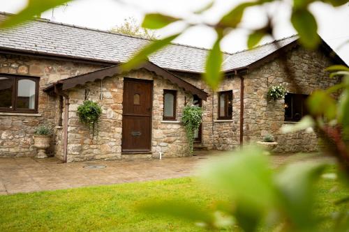 a stone house with a brown door and a yard at The Forge in Swansea