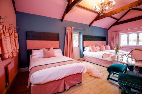 two beds in a room with pink and blue walls at The Forge in Swansea