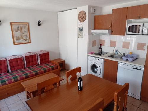 a kitchen and living room with a table and a couch at Agréable appartement avec balcon dans résidence calme in Cauterets