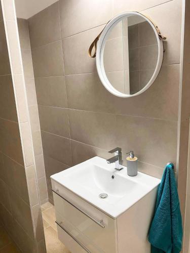 a bathroom with a sink and a mirror at Platános Apartman Tata in Tata