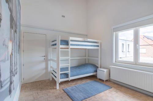 a bedroom with a bunk bed and a window at Ruime woning met grote omheinde tuin in Hasselt