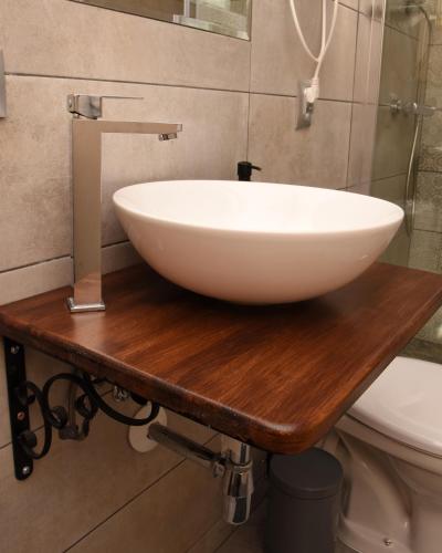 a white bowl sink on a wooden counter in a bathroom at B10 Pan i Pani Żuraw nad Jeziorem in Ełk