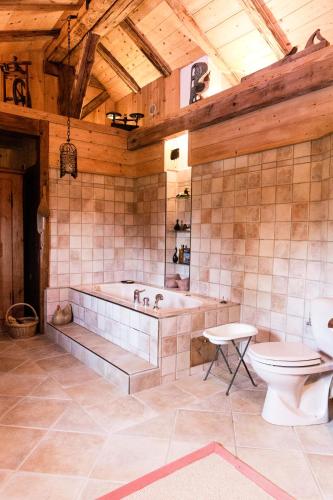 La grande salle de bains est pourvue d'une baignoire et de toilettes. dans l'établissement Chalet familial authentique avec jardin/cheminée, à Samoëns