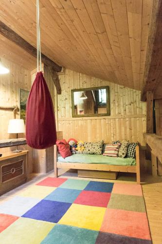 - un canapé dans une chambre dotée d'un tapis coloré dans l'établissement Chalet familial authentique avec jardin/cheminée, à Samoëns