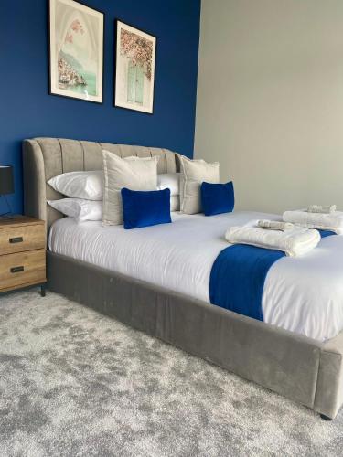 a bedroom with a large bed with blue walls at Stunning modern home set in beautiful grounds. in Bath