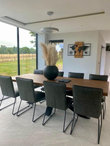 a dining room table with chairs and a vase on it at Stunning modern home set in beautiful grounds. in Bath