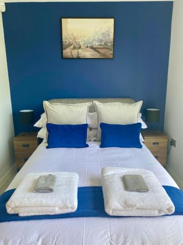 a blue bedroom with a large bed with blue walls at Stunning modern home set in beautiful grounds. in Bath
