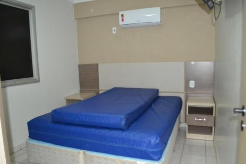 Habitación con cama azul en una habitación en Apartamento Aquarius Residence, en Caldas Novas