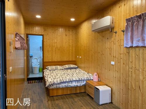 a bedroom with a bed in a wooden wall at Zhenan Pink Panther in Linbian