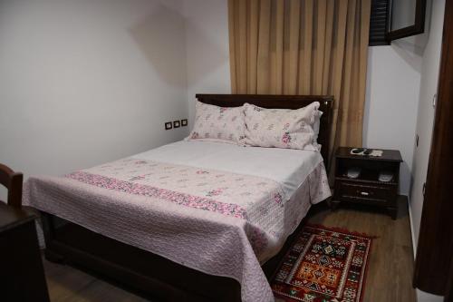 a bedroom with a bed with a pink blanket and pillows at Hotel Kaceli in Berat