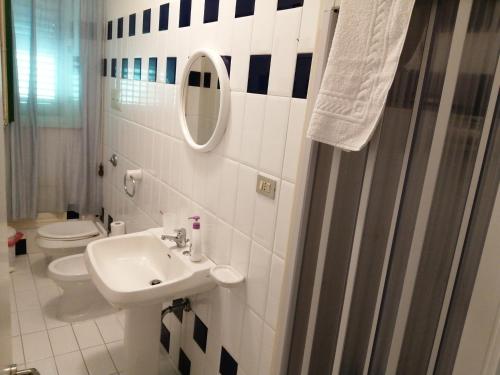 ein Badezimmer mit einem Waschbecken, einem WC und einem Spiegel in der Unterkunft Villa Buonasera in Santa Flavia